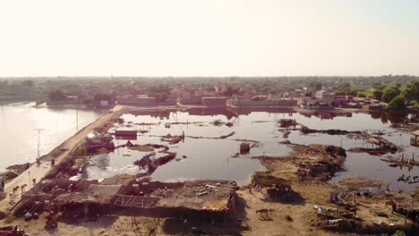 Aerial-Ascending-Shot-View-Beside-Road-To-Reveal-Stagnant-Flood-Waters-In-Field-In-Daharki,-Pakistan