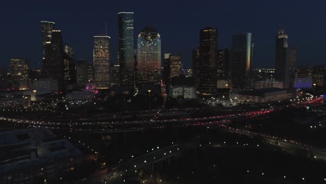 this video is about an aerial view of downtown houston at night with traffic going pass downtown