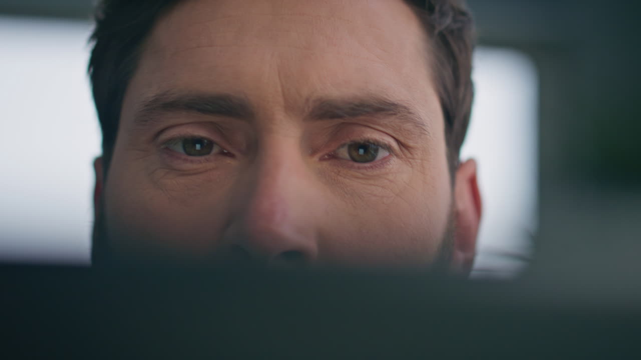 Focused man eyes reading tablet screen home closeup. Frowning guy watching pad