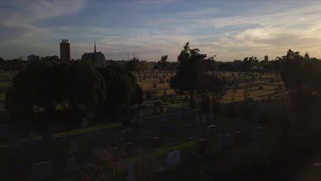 backwards dolly shot showing a graveyard during sunset