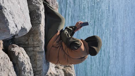 woman using phone by the sea