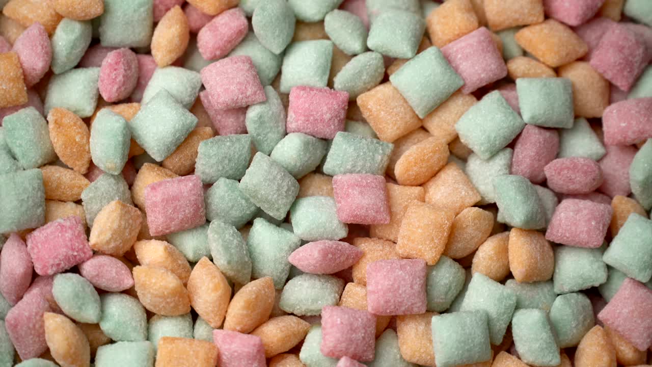 almohadillas de caramelo dulces mezcladas con azúcar de bocadillo girar el fondo