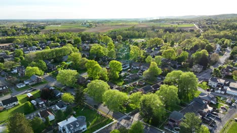 Eine-Langsame-Filmische-Luftschwenkaufnahme-Eines-Vororts-Einer-Kleinstadt-Und-Der-Skyline-Der-Stadt-über-Den-Straßen-Und-Häusern-Der-USA