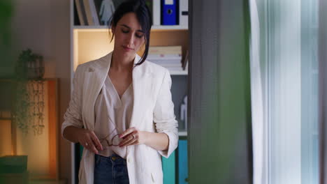 Pensive-Businesswoman-Stands-by-Window-Thinking