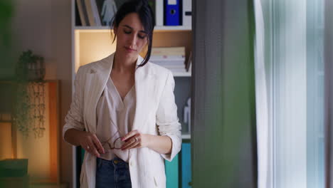 una mujer de negocios pensativa está pensando junto a la ventana.