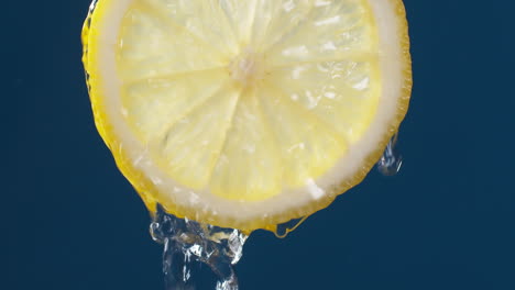 Slow-Motion-Macro-Shot-of-Flowing-Water-from-Lemon-Slice-on-blue-black-Background