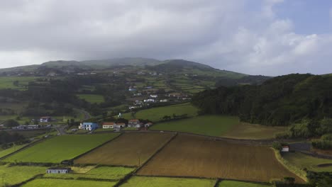 rural coastal village with crop fields, sunny, cloudy sky in topo, são jorge island, the azores, portugal