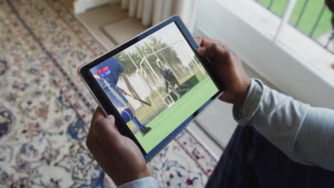 Composite-of-man-sitting-at-home,-watching-hockey-match-on-tablet