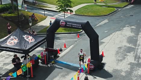 runner approaching finish line at tacos and tequila 5k race in suwanee, georgia. high angle shot