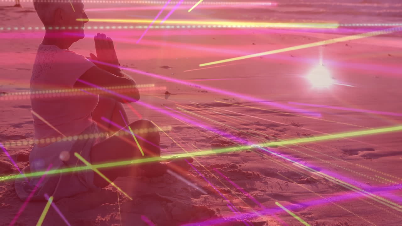 Meditating on beach, person surrounded by colorful animation light streaks