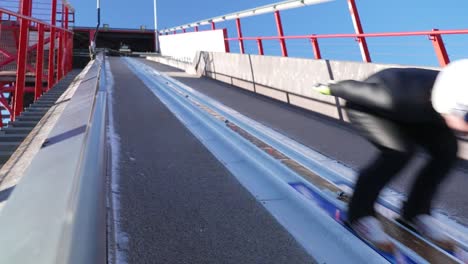 Slow-motion-shot-of-the-ski-jumper-moving-down-the-ski-tower