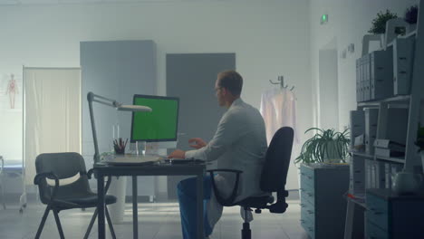 doctor using green screen computer consulting patient online in hospital office.