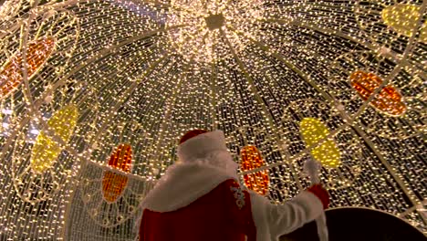 santa claus under a festive light display