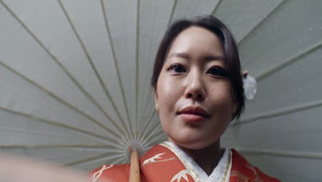 woman in kimono under a traditional japanese umbrella