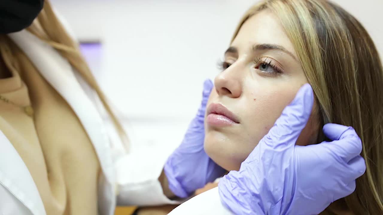 cosmetóloga anónima preparándose para inyectar botox en el rostro femenino