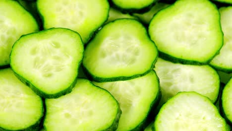 round slices of fresh cucumber slowly rotate. top view, spinning slowly in a circle