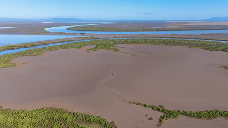 aerial flies across a series of strange wetland landscapes with giant pans of mud, islands of mangrove, and languid slow waterways. port alma raglan australia