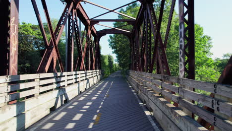 Crossing-the-abandoned-Arkwright-Bridge-over-the-Pawtuxet-River-in-West-Warwick,-Rhode-Island