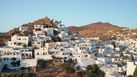 Vista-Aérea-De-Drones-De-Casas-En-Las-Montañas-De-La-Playa-En-La-Isla-De-Ios