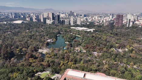 drone view of chapultepec forest lake surrounded by towering skyscrapers of polanco in cdmx