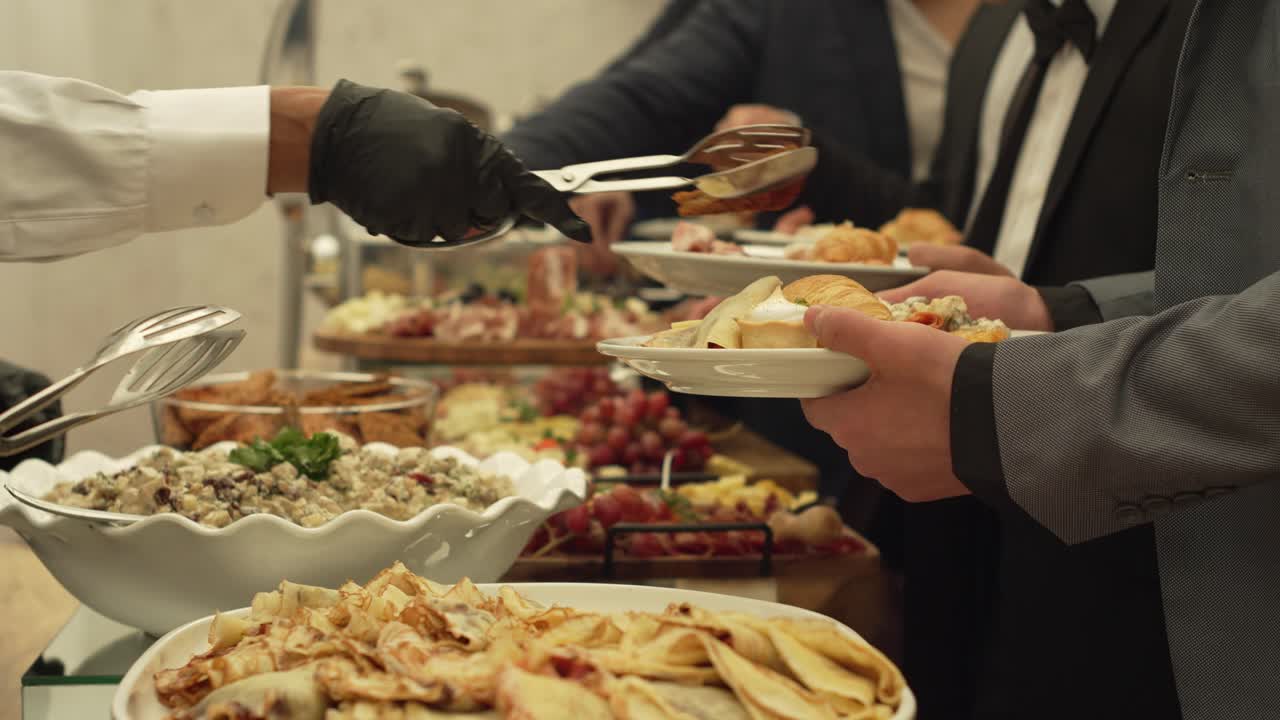 A group of people are serving food at a buffet. Scene is casual and social event. Brunch catering.