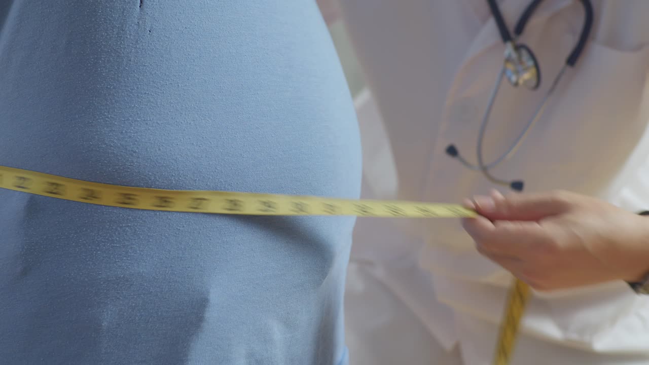 Close Up Side View Of Male Doctor'S Hands Using Tape Measuring Fat Male Patient'S Waist