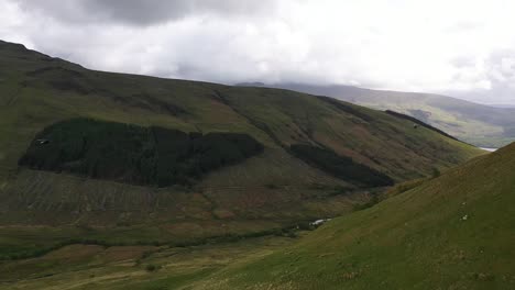 ángulo-Aéreo-De-Helicópteros-Que-Vuelan-Hacia-El-Valle-De-Glen-Douglas-En-Las-Tierras-Altas-Escocesas-Cerca-De-Loch-Lomond