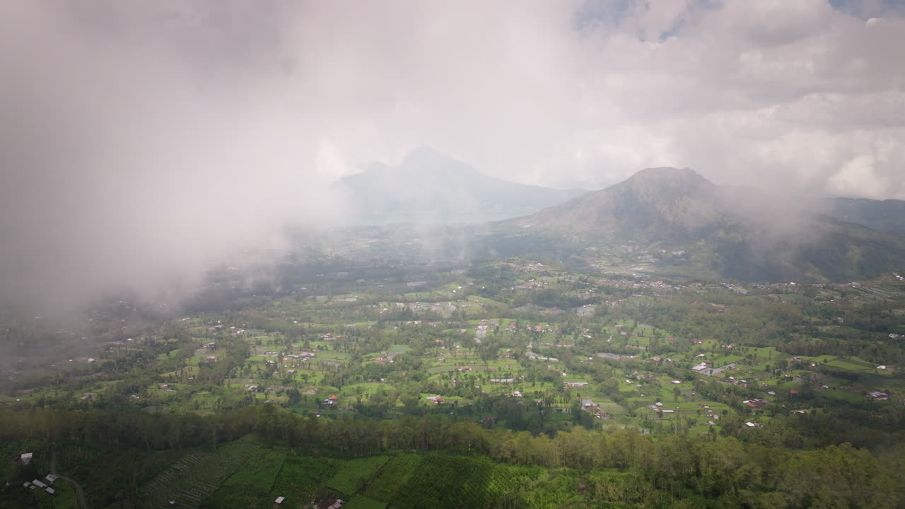 paisaje atmosférico de nubes sobre una aldea rural cerca del monte batur en bali, indonesia