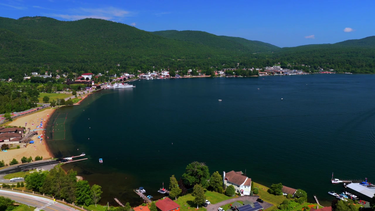 Million Dollar Beach zwemstrand Lake George staat New York luchtdrone stad Lake George Steamboat Company veerboten landschap zomer juli zonnige ochtend blauwe lucht Adirondack-bergen voorwaartse pan
