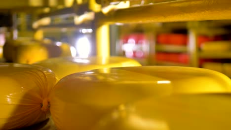 una vista de cerca de las ruedas de queso amarillas en un estante.