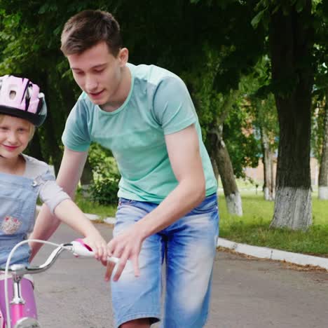 Der-ältere-Bruder-Bringt-Seiner-Schwester-Das-Fahrradfahren-Bei-Die-Ersten-Erfolge-Von-Kindern
