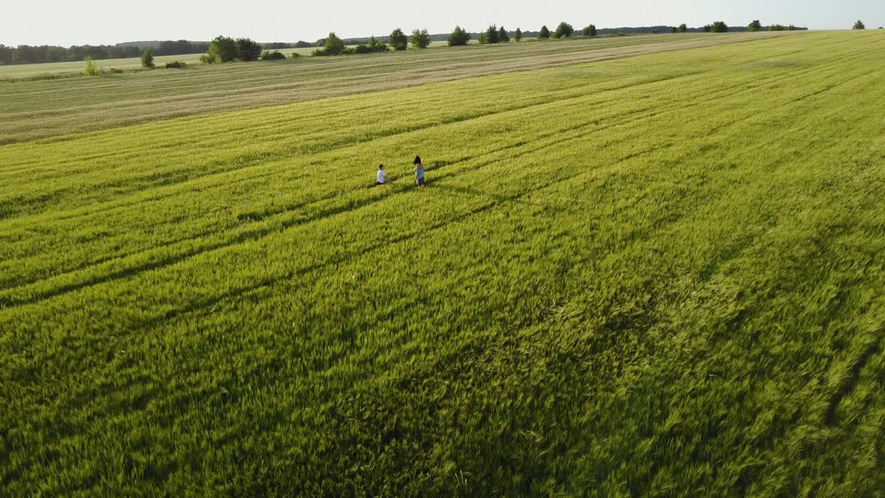 Mother With Her Younger Son. Family mother with her son are walking around the field
