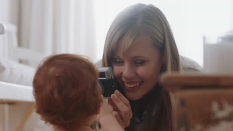 happy mother taking photo of baby using camera excited mom photographing cute toddler enjoying motherhood lifestyle making memories
