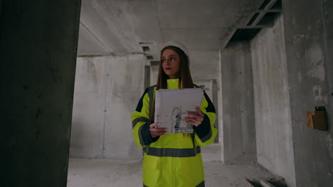young-female-civil-engineer-is-walking-in-building-under-construction-portrait