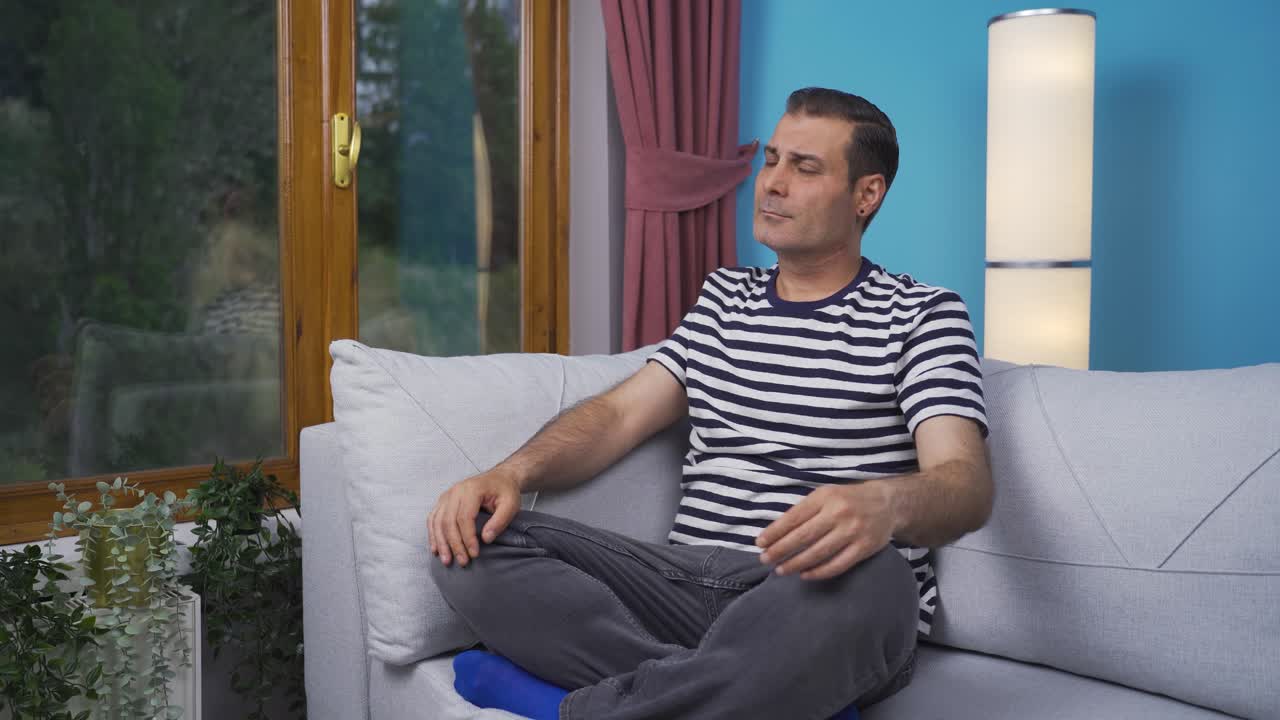 창문 앞에서 요가를 하는 남자.