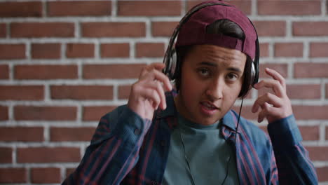 retrato relajado joven estudiante universitario hombre escuchando música toma auriculares sonriendo confiado disfrutando de un estilo de vida despreocupado cámara lenta