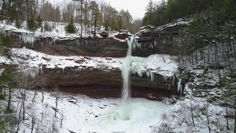 hermoso tiro aéreo de invierno volando hasta una cascada en un paisaje helado