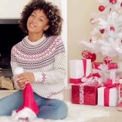 Smiling-young-woman-holding-a-Santa-hat