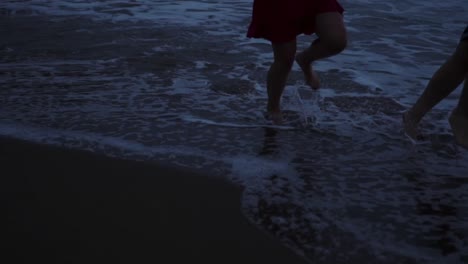 Pareja-Anónima-Corriendo-En-La-Playa-De-Noche