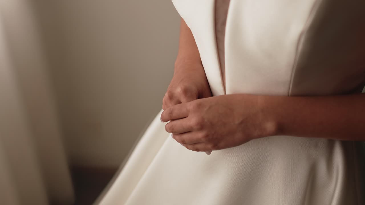 웨딩드레스를 손질하는 신부의 클로즈업 사진