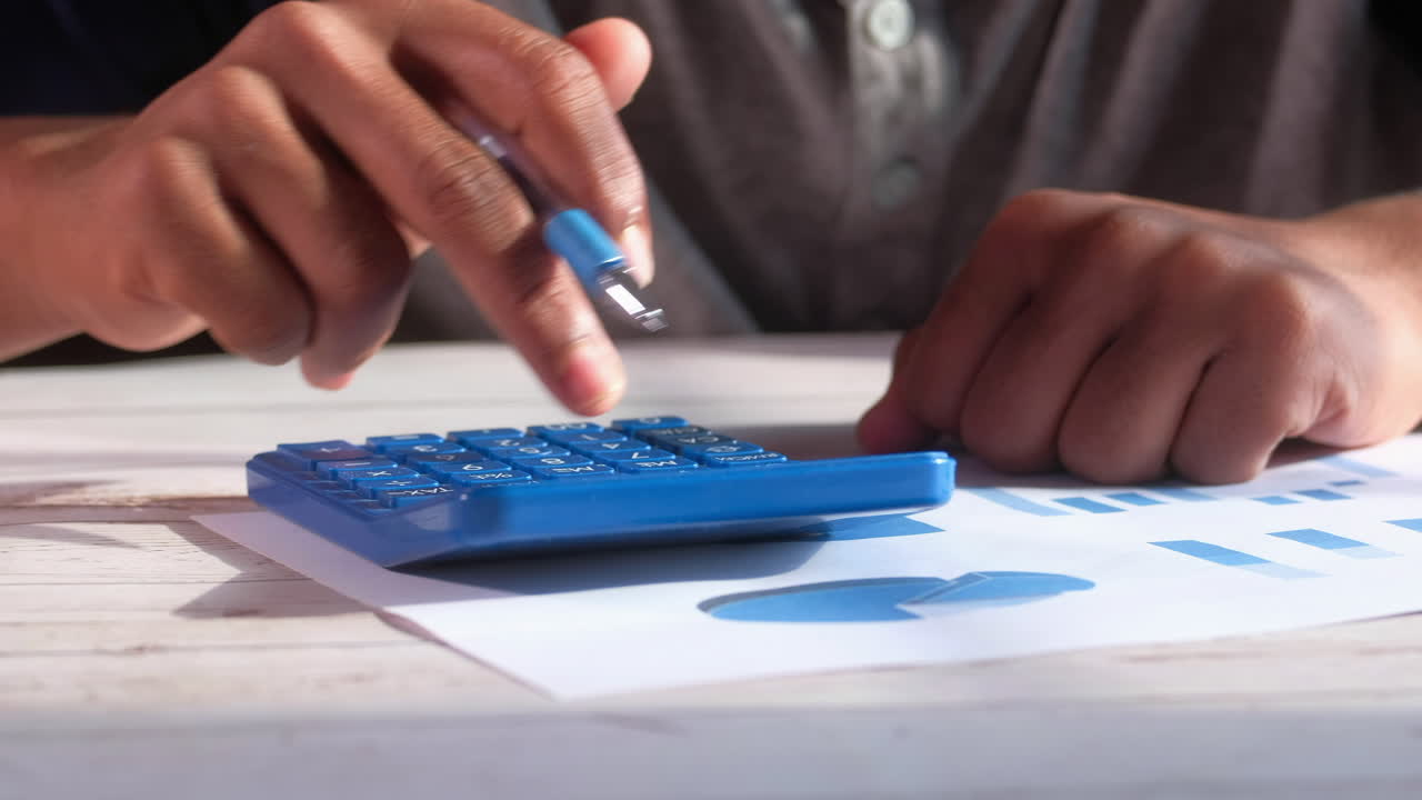 persona que hace cálculos con calculadora y gráficos