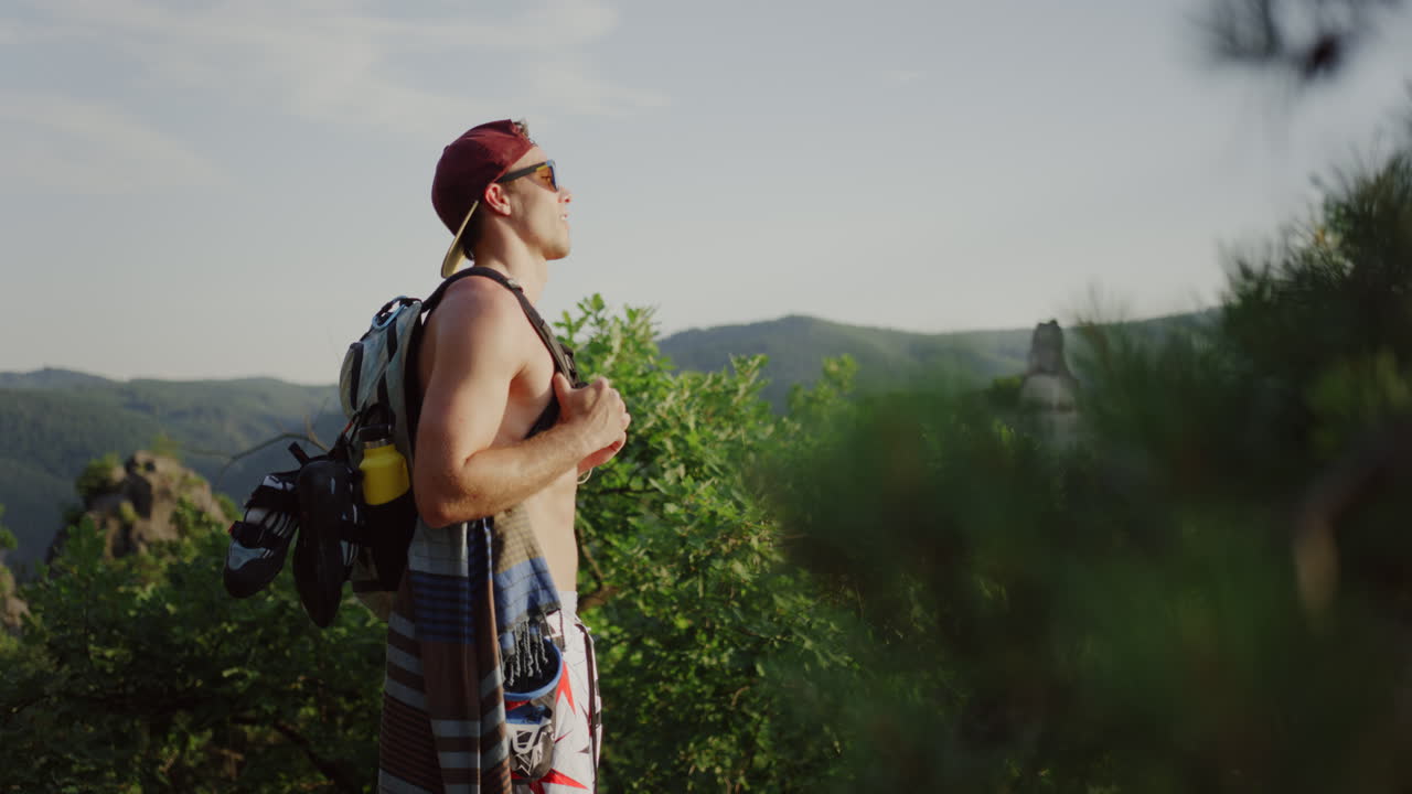 hombre mirando sobre el paisaje verde de la montaña en el fondo, tranquila luz del sol turista soleado, sendero de senderismo colinas valle caminata ruta de senderismo austria ruta de caminata al aire libre, persona masculina tomando un descanso