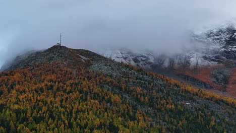 Foggy-morning-rain-Saas-Fee-Saastal-Switzerland-aerial-drone-gondola-Metro-Alpin-tram-Swiss-Alpine-Alps-chalet-valley-mountains-morning-glacier-Feevispa-yellow-orange-larch-forest-upwards