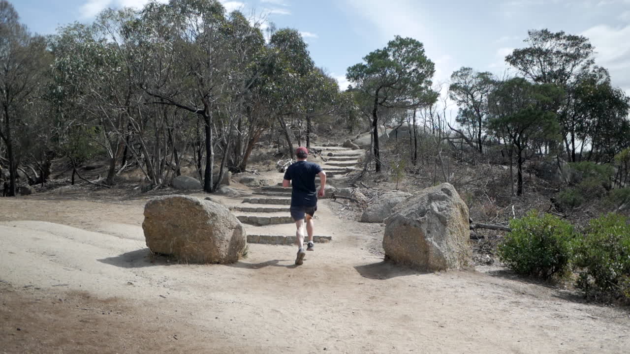 you yangs national park, victoria australia의 정상까지 계단을 달리는 남자