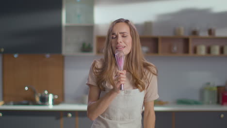 mujer cantando en la cocina