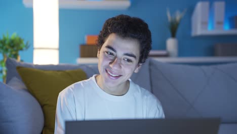 retrato en primer plano de un adolescente sonriendo y usando una computadora portátil para enviar mensajes de texto en las redes sociales