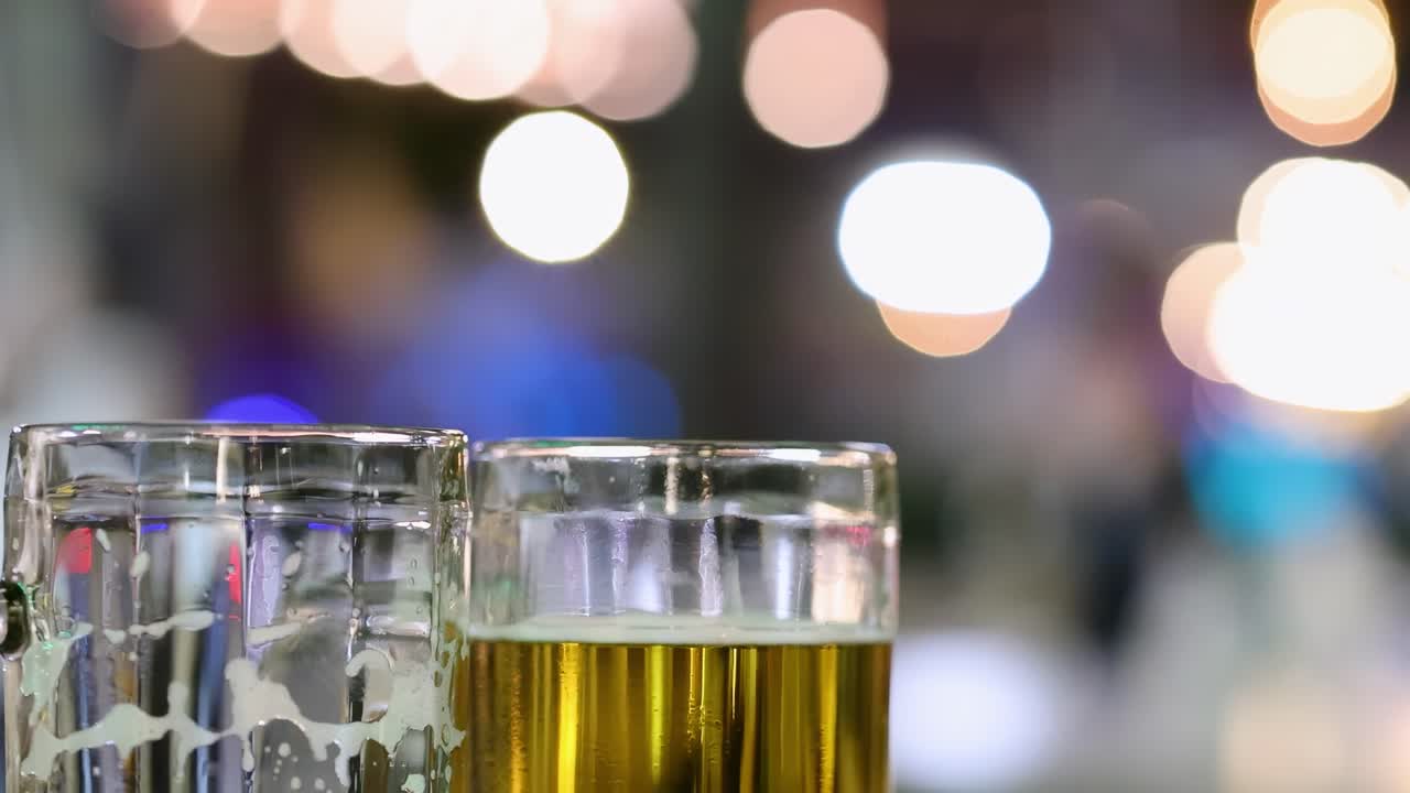 Focused beer glasses with a backdrop of colorful bokeh lights, creating a vibrant and festive atmosphere.