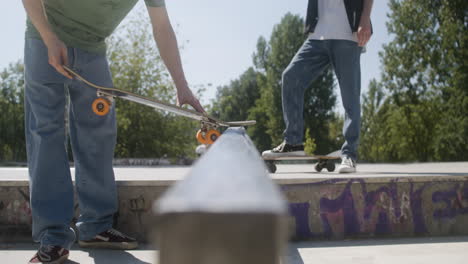 Close-up-view-of-boy-explaining-a-trick-to-his-friend-in-skatepark.