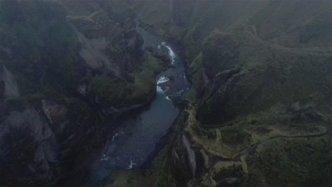 Disparo-De-Dron-Volando-Sobre-El-Cañón-Nublado-Fjaðrárgljúfur-Con-La-Cámara-Inclinada-Hacia-Abajo-En-Islandia-4k