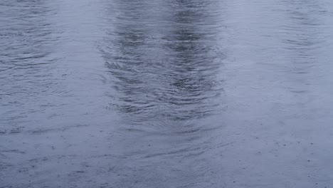 Water-surface-during-light-rain-with-raindrops-in-Blue-Hue